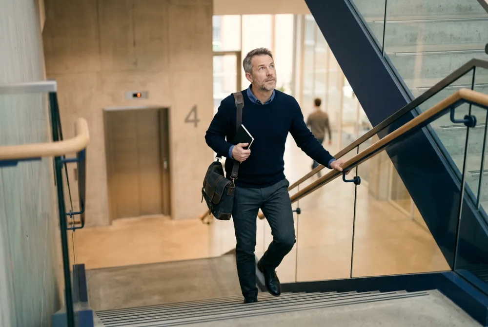 Hombre subiendo por las escaleras en una oficina
